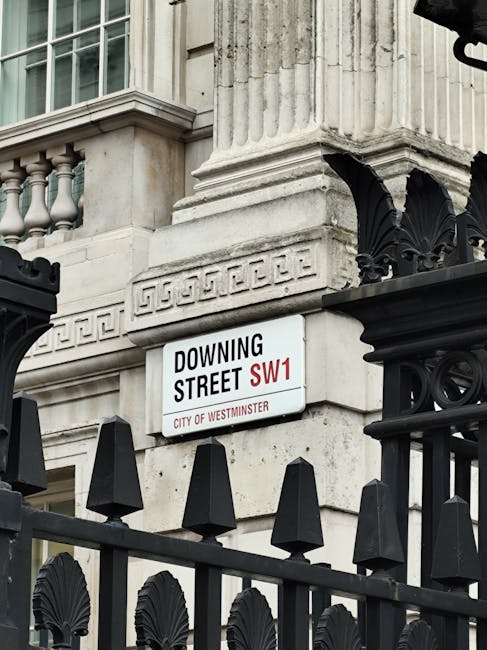 A street corner featuring a brick building with a white-framed window and an street sign indicating Great Peter Street SW1 in the City of Westminster. In the background, there is an ornate classical-s